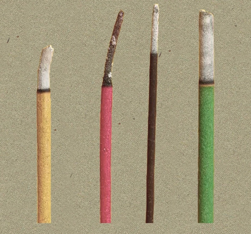 Comparison of synthetic incense sticks showing colored coatings and uneven ash after burning.