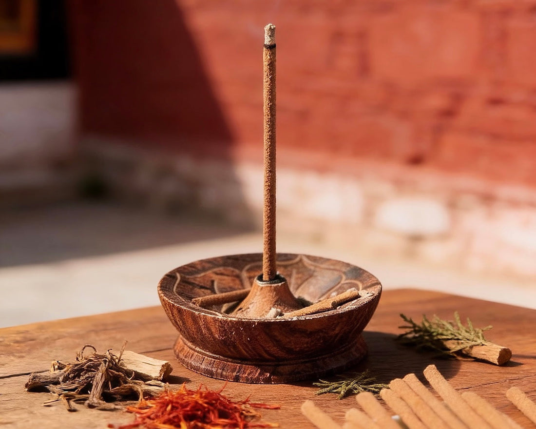 Single Tibetan incense stick placed in a carved wooden incense holder with natural herbs.