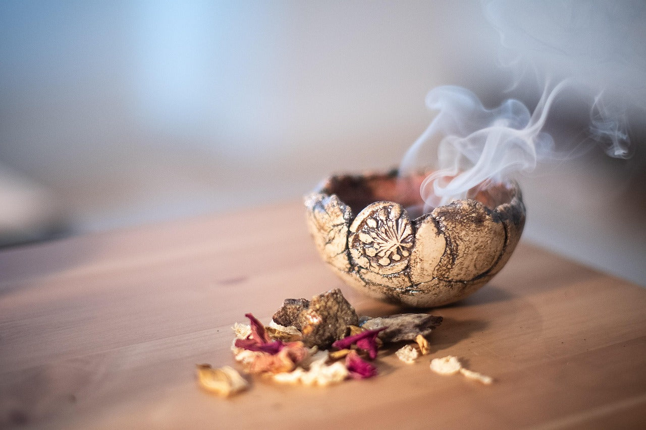 Natural incense burning in a handmade ritual bowl, releasing gentle smoke to create a calm, grounded, and meditative atmosphere.