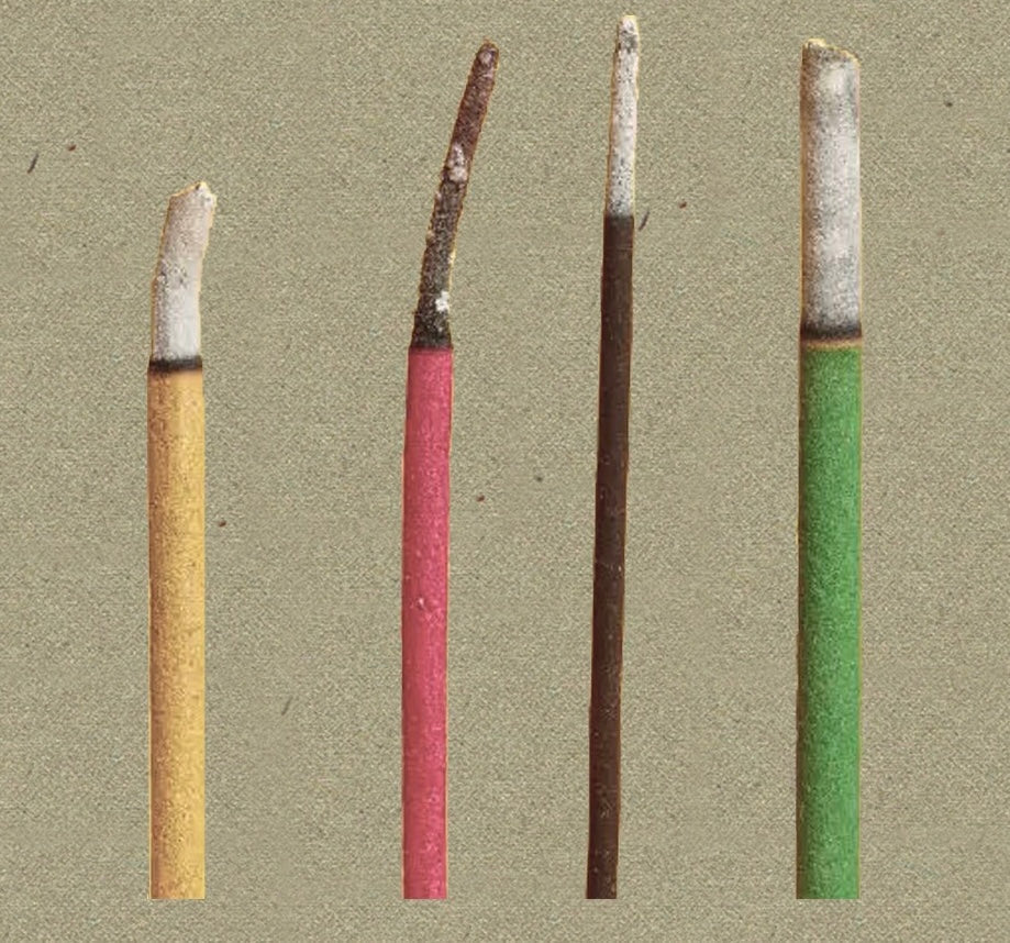 Comparison of synthetic incense sticks showing colored coatings and uneven ash after burning.