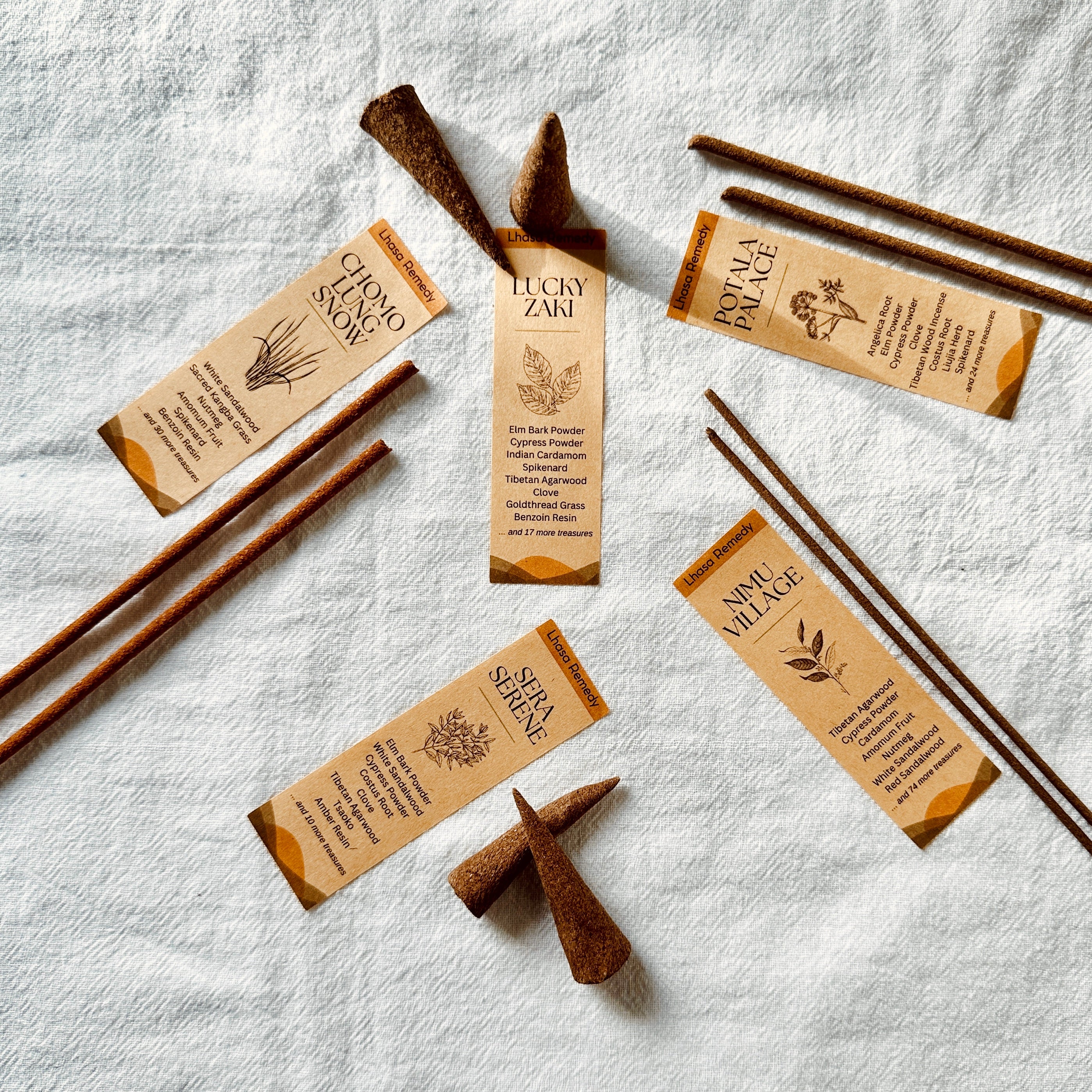 Flatlay of the All Mine incense set by Lhasa Remedy, featuring five signature Tibetan scents—Lucky Zaki, Chomolung Snow, Potala Palace, Nimu Village, and Sera Serene—with cones and sticks arranged on a white cloth.