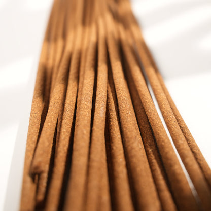 Close-up view of Chomolung Snow Tibetan incense sticks, highlighting the fine texture and warm brown tone under natural light with soft shadows.