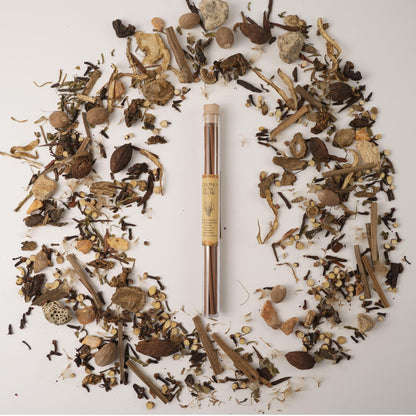 Chomolung Snow Tibetan incense sticks in a glass tube, surrounded by traditional Chinese medicinal herbs on a white background.