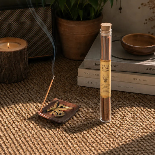 Lhasa Remedy Chomo Lung Snow Tibetan herbal incense stick burning in holder beside glass tube