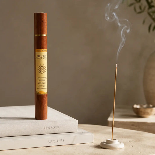 Lhasa Remedy The First Sambuchu Tibetan incense burning on stone holder beside rosewood tube on books