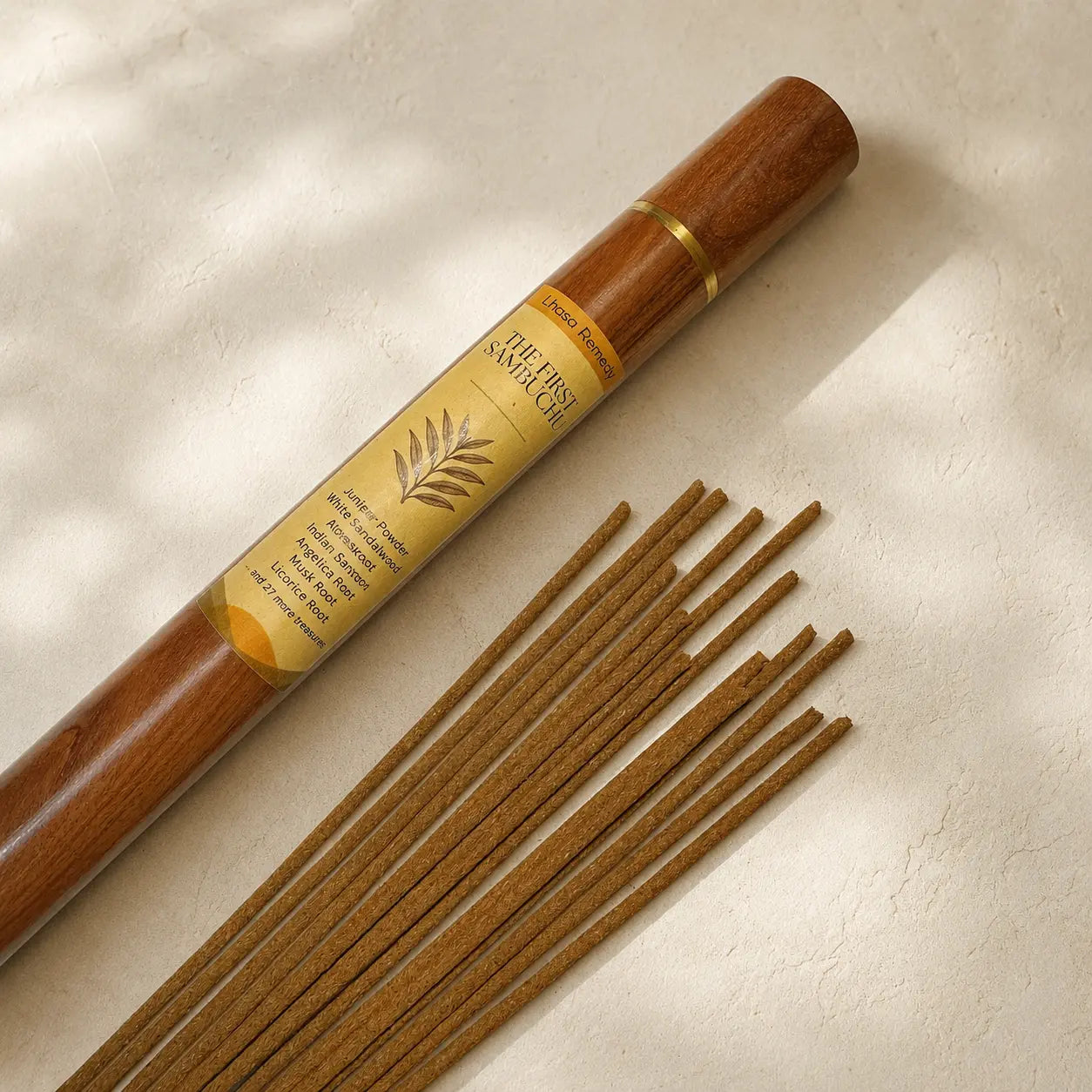 Lhasa Remedy The First Sambuchu Tibetan incense sticks flat lay beside rosewood tube juniper sandalwood