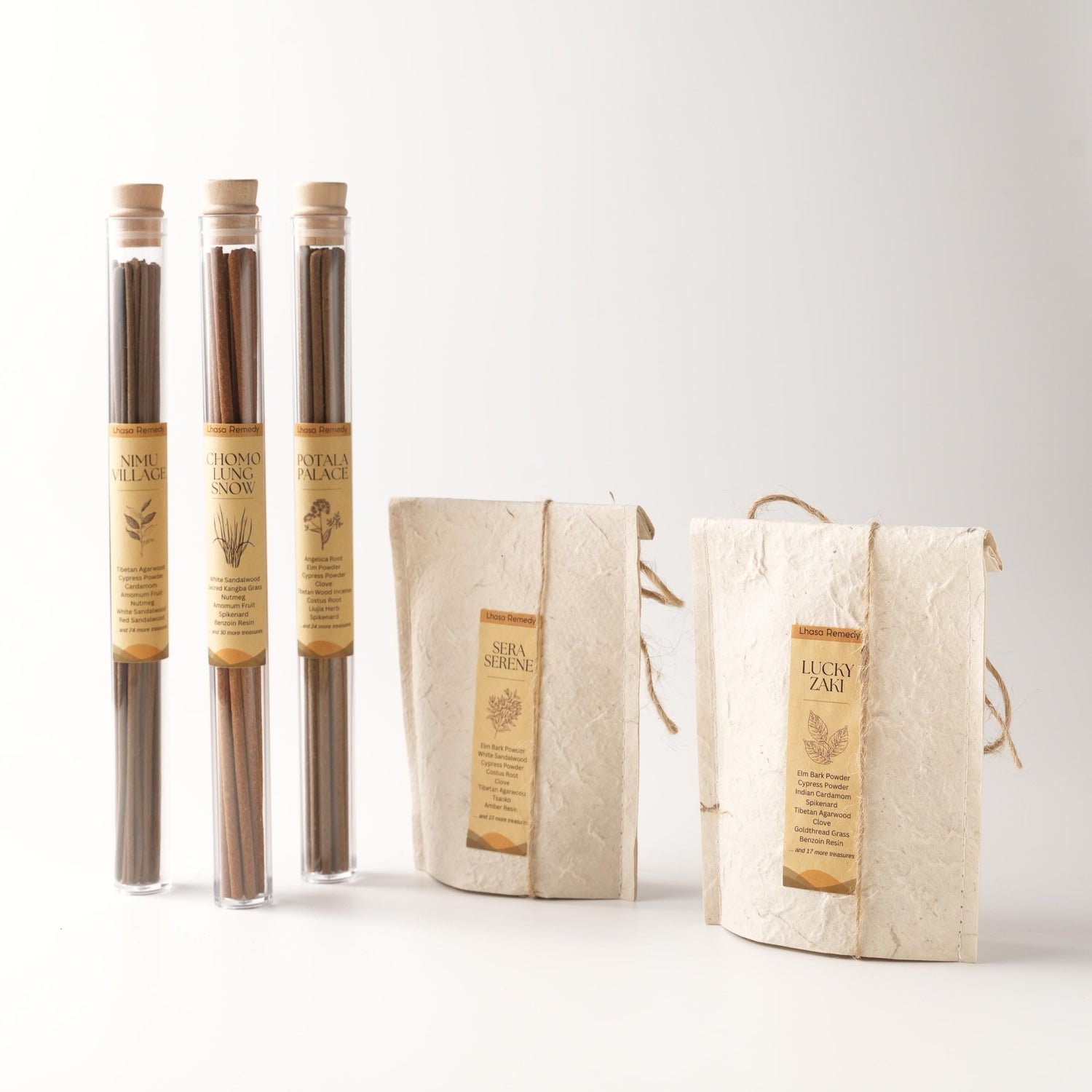Lhasa Remedy’s complete incense collection featuring three glass tubes of stick incense (Nimu Village, Chomolung Snow, Potala Palace) and two handmade paper pouches containing cone incense (Sera Serene and Lucky Zaki), arranged neatly against a light background.