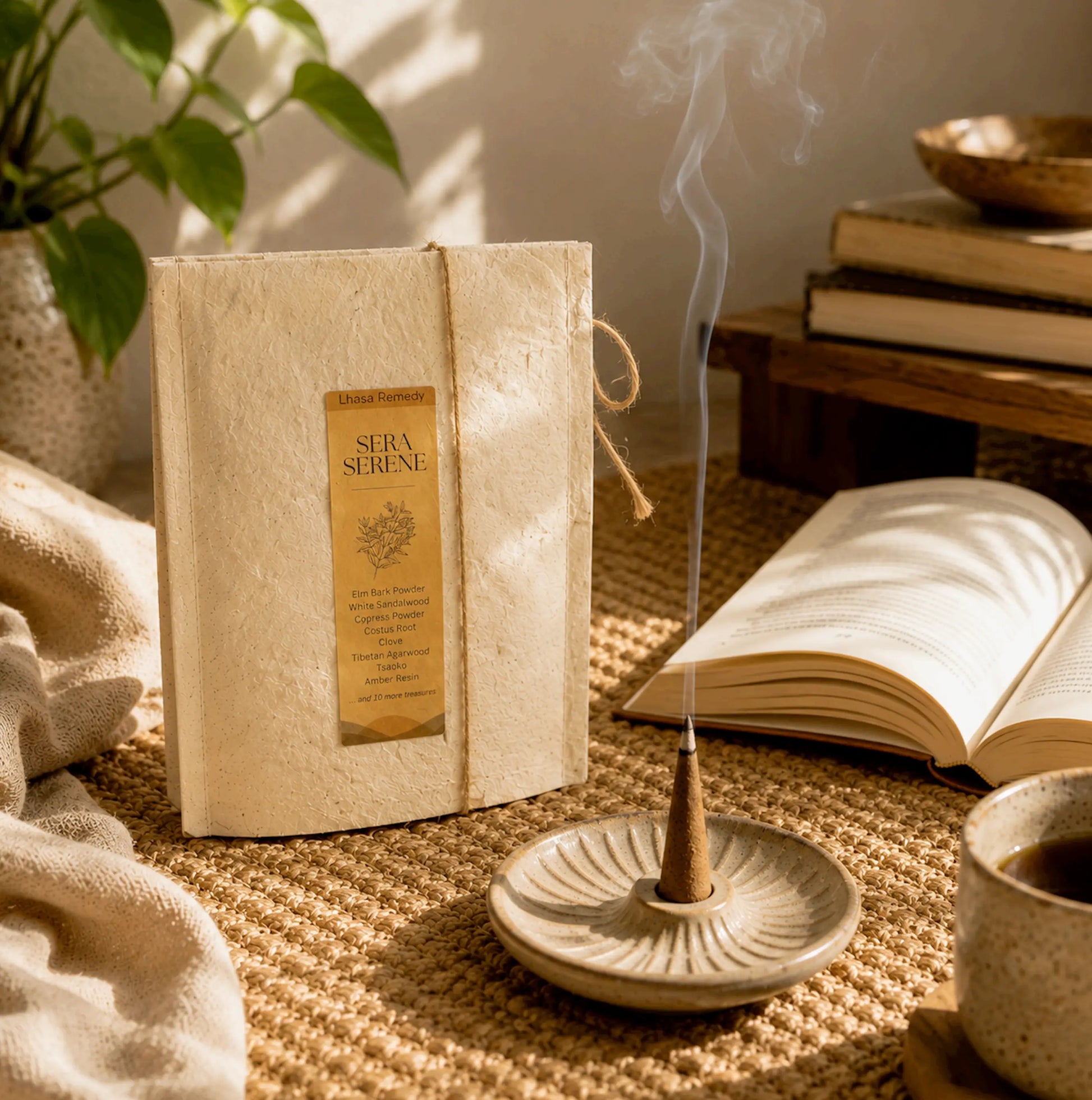 Lhasa Remedy Sera Serene Tibetan incense cone burning in ceramic dish beside open book on jute rug cozy lifestyle