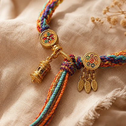 Lhasa Remedy Tibetan lucky bracelet rainbow braided thread with gold mandala charm macro close-up