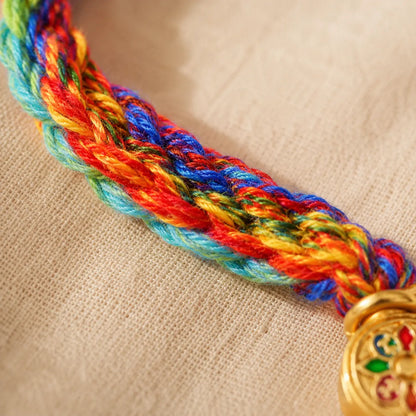 Lhasa Remedy Tibetan prayer bracelet close-up gold prayer wheel charm mantra disc dreamcatcher pendant