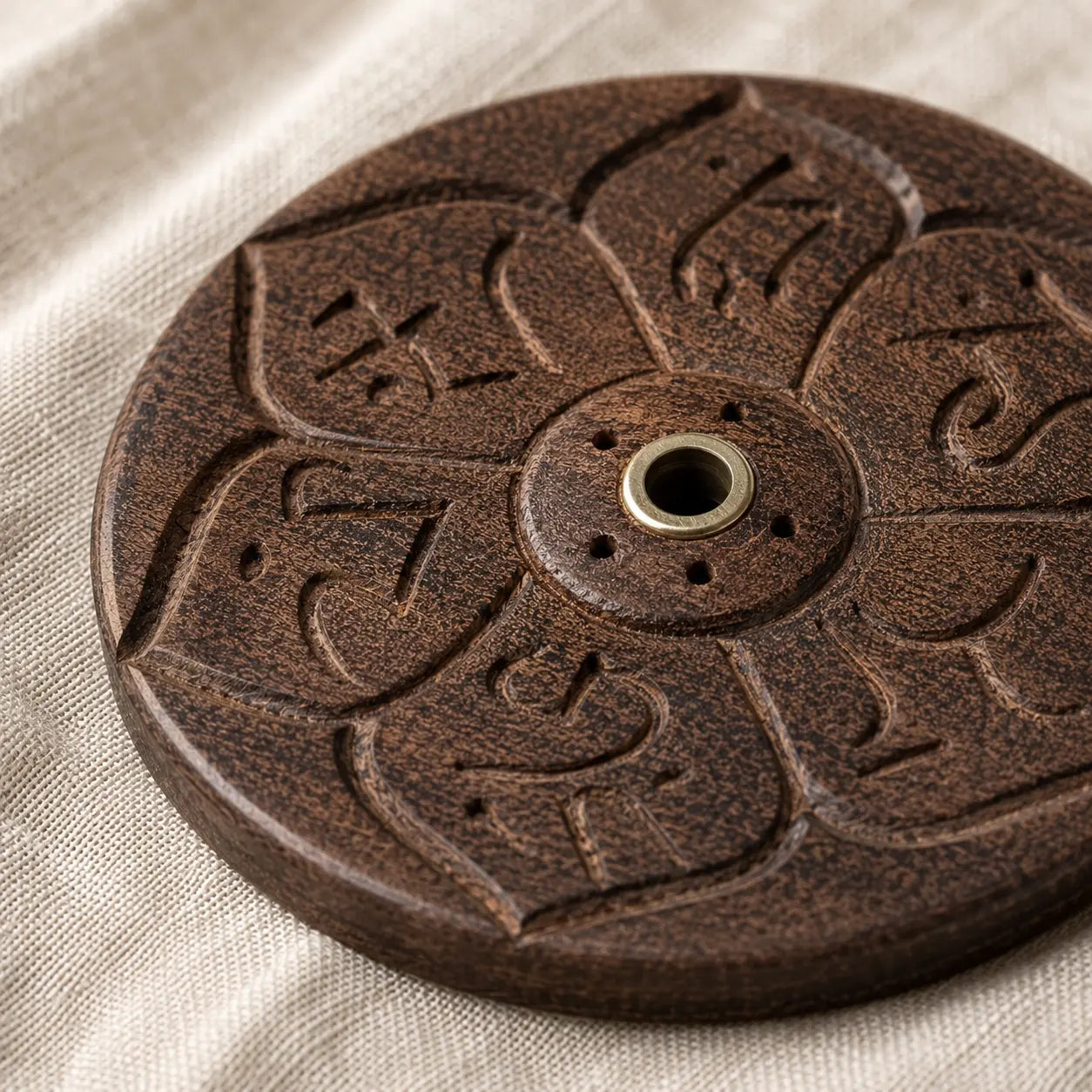 Lhasa Remedy wooden round mandala incense holder held in hand showing size with Tibetan incense stick beside it