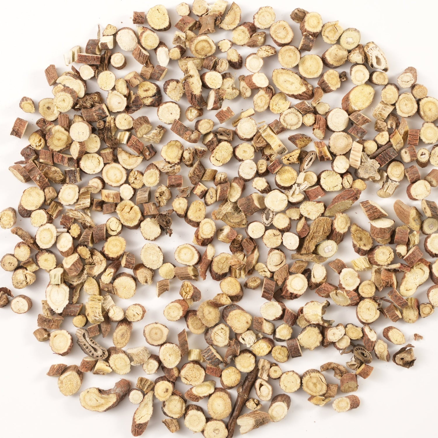 Thin round slices of dried licorice root arranged in a circular shape on a white background. A classic adaptogenic herb used in Tibetan incense to harmonize formulas, soothe the respiratory system, and support vitality.