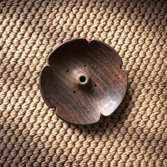 Top view of open petal incense holder carved from natural wood, showing concave lotus shape and central incense hole