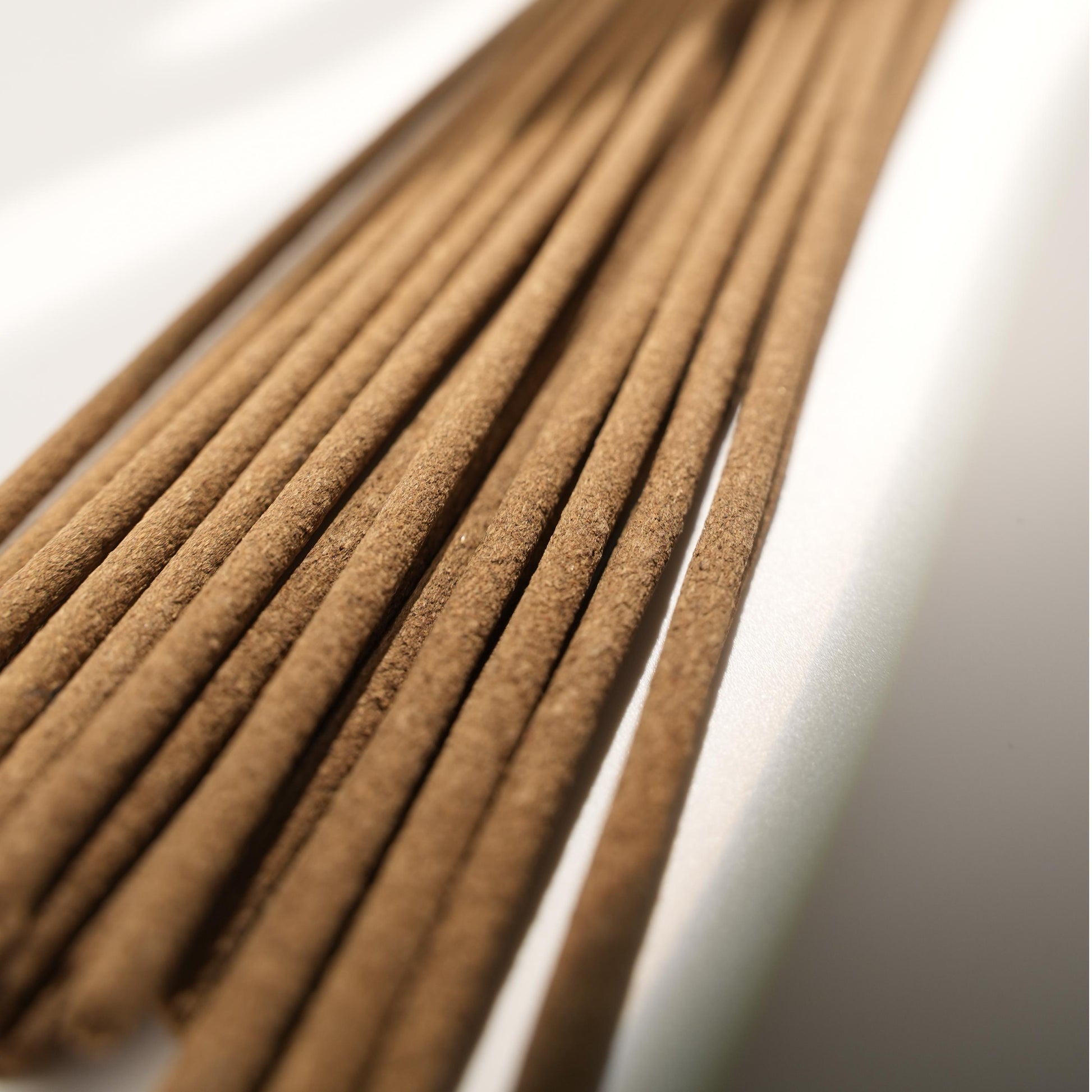 Close-up view of Potala Palace Tibetan incense sticks, showing the smooth, fine-grained texture under soft daylight with natural shadow play.