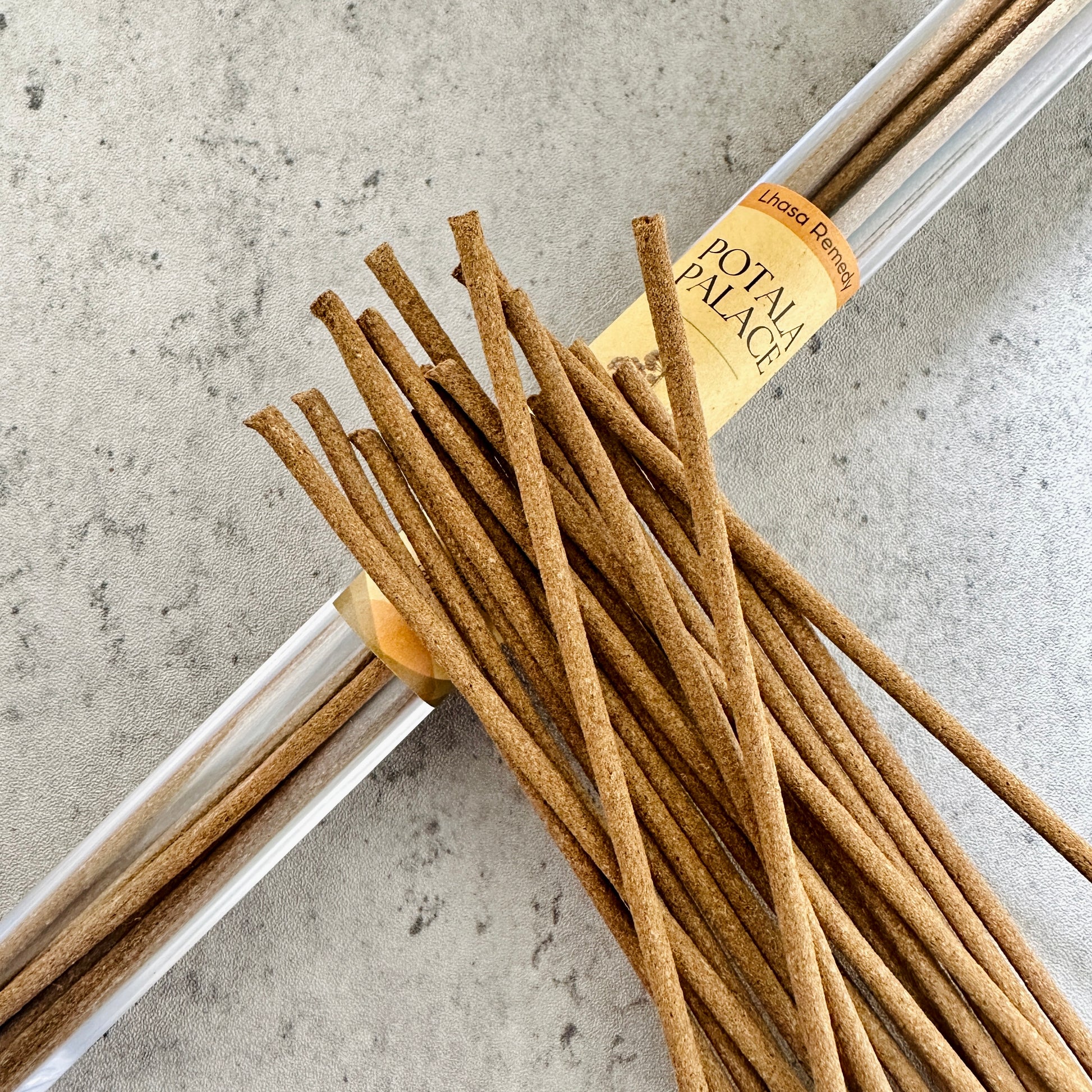 Potala Palace incense sticks from Lhasa Remedy arranged beside a clear tube, inspired by the regal essence and ancient wisdom of Tibetan royalty.