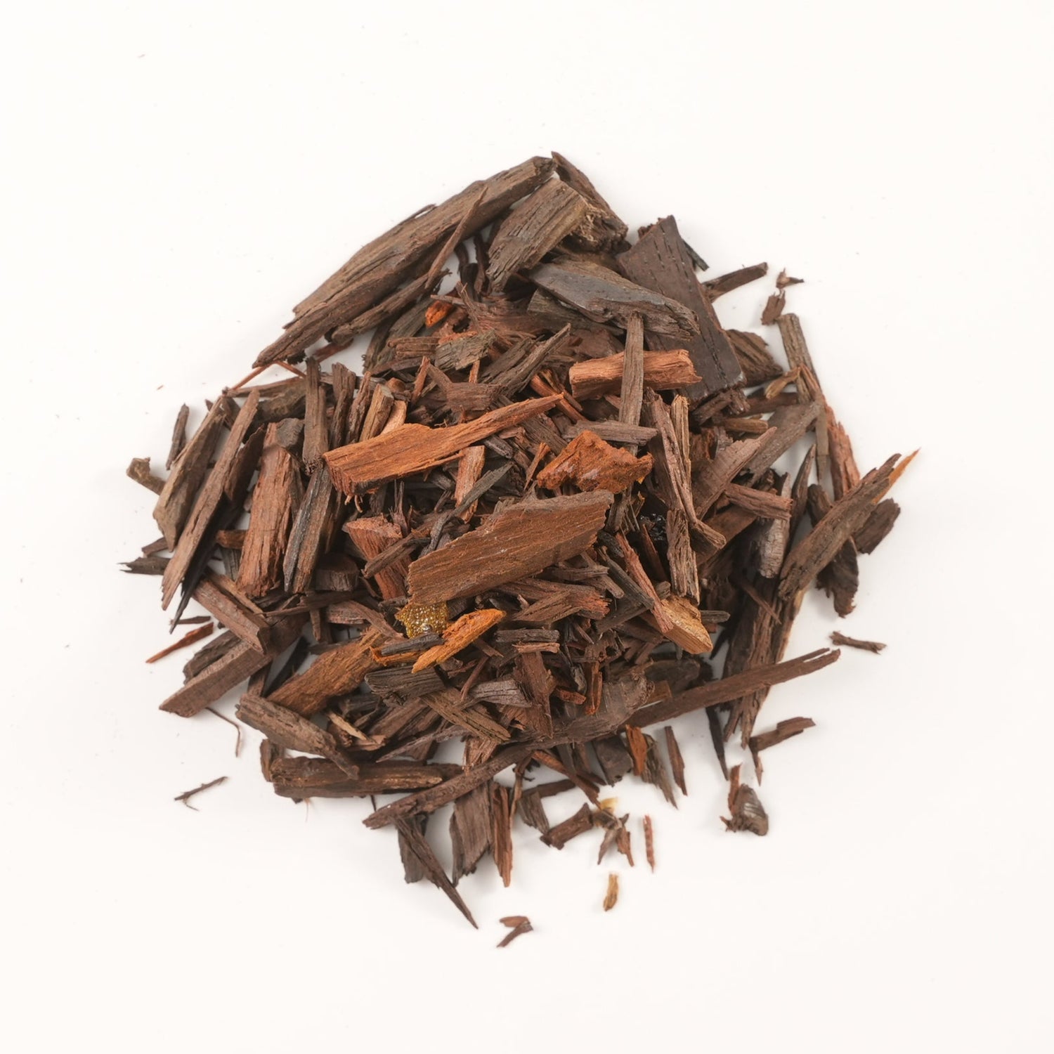 A small pile of red sandalwood chips on a white background. Known for its grounding aroma, red sandalwood is used in Tibetan incense to calm the mind, reduce inflammation, and support spiritual clarity.