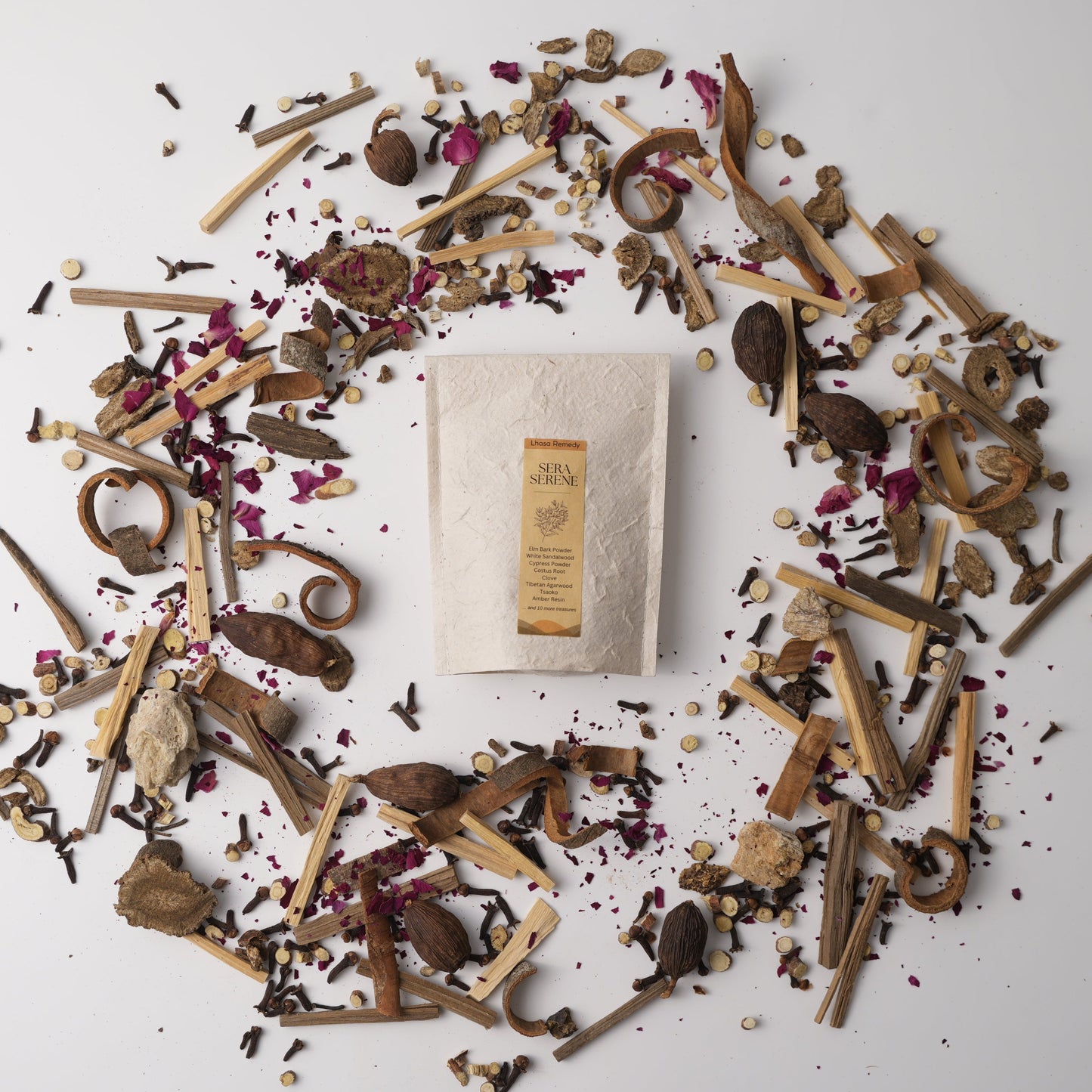 Sera Serene Tibetan incense surrounded by calming herbs, roots, woods, and flower petals—capturing the essence of a grounding and meditative ritual blend.