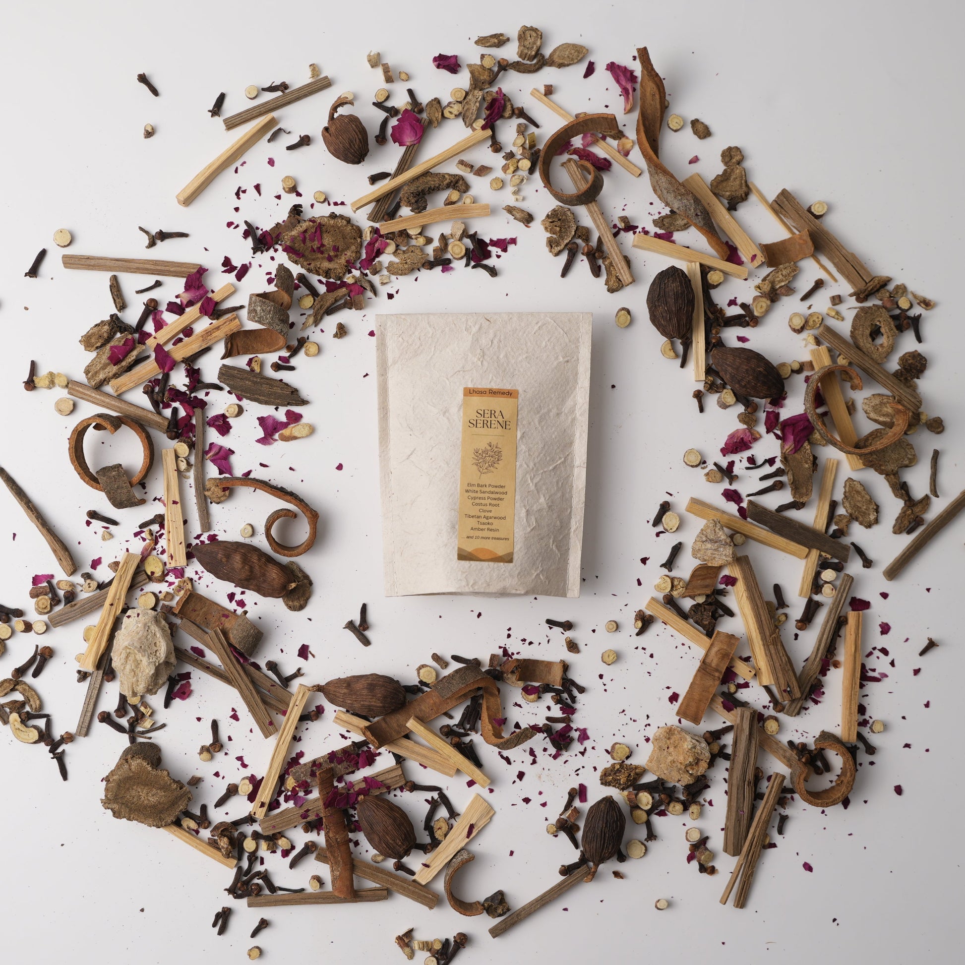 Sera Serene Tibetan incense surrounded by calming herbs, roots, woods, and flower petals—capturing the essence of a grounding and meditative ritual blend.