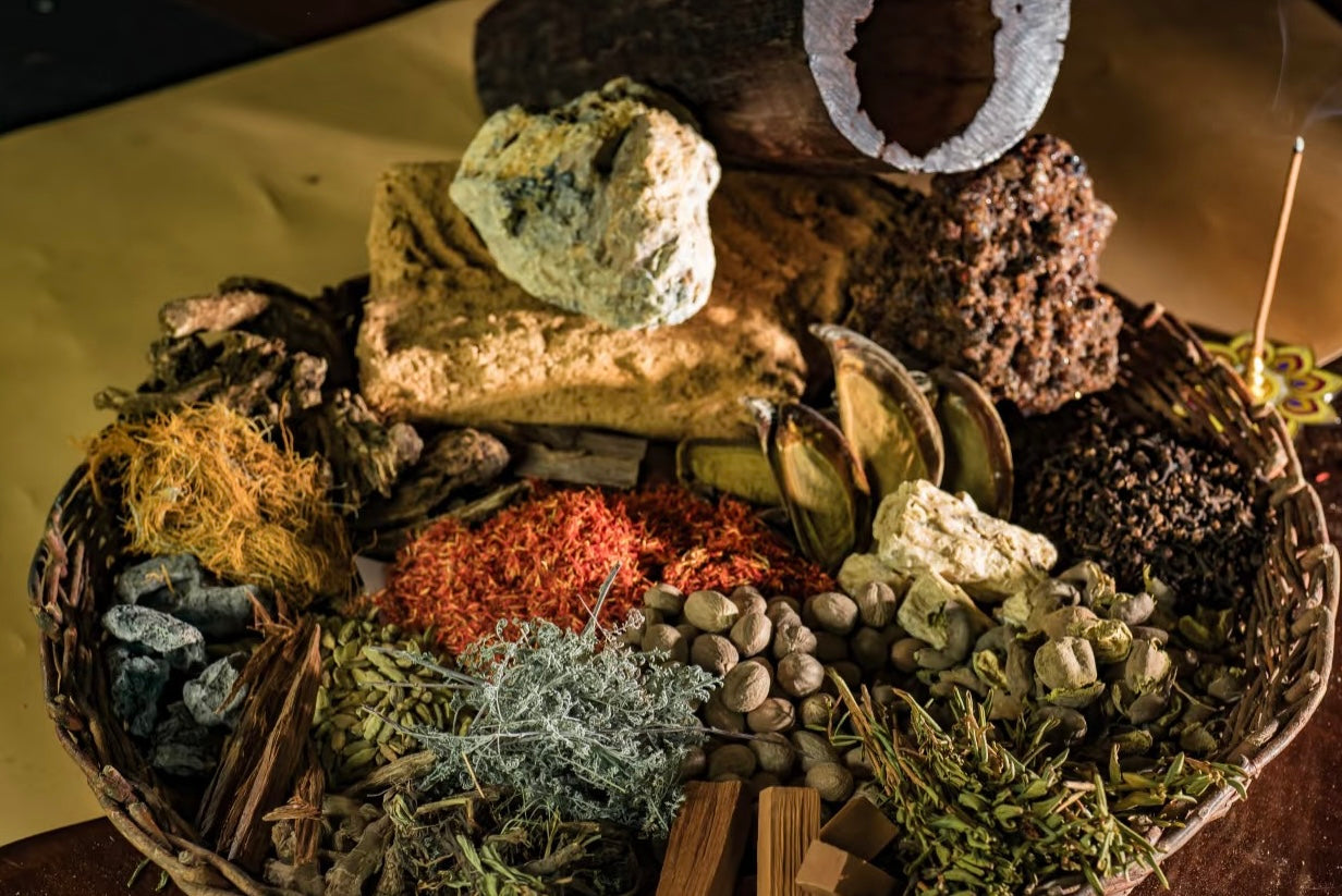 Basket filled with diverse Tibetan incense ingredients including herbs, spices, woods, and resins.