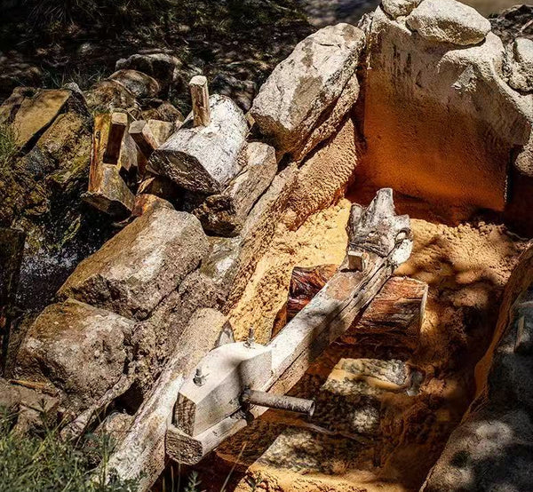 Traditional water-powered grinding setup used to grind Himalayan incense herbs into fine powder.